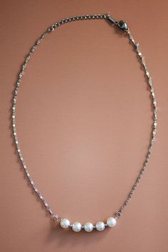 This dainty silver necklace is all one length. Its chain is simple but ends with white pearls. Length: 8 1/2” Minimalist Metal Chain Necklace With Pearl, Minimalist Metal Pearl Chain Necklace, Delicate Silver Necklace With Pearl Chain, Dainty Metal Chain Necklace For Formal Occasions, Dainty Silver Single Strand Necklace, Delicate Silver Pearl Necklace With Delicate Chain, Minimalist Single Strand Chain Necklace For Formal Occasions, Dainty Silver Link Necklace, White Gold Delicate Chain Necklace