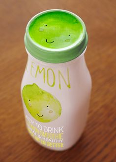 a bottle of lemon yogurt sitting on top of a wooden table next to a spoon