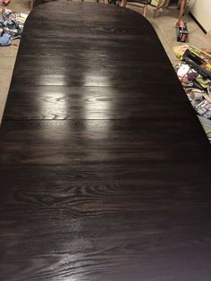 a large wooden table sitting on top of a floor next to other furniture and tools