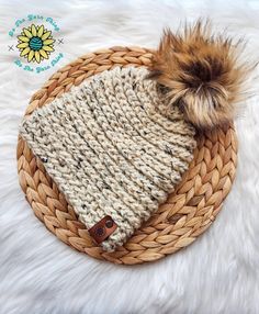 a knitted hat with a brown pom - pom on top