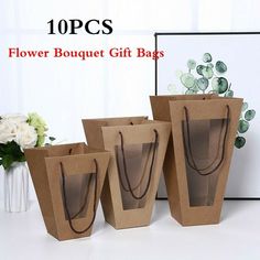 three brown paper bags with flowers in them