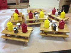 four wooden trays with hot dogs and ketchup on them sitting on a table