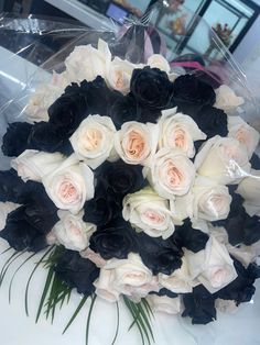 a bouquet of white and black roses on a table