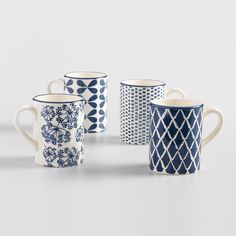 four blue and white coffee mugs sitting next to each other on a gray surface