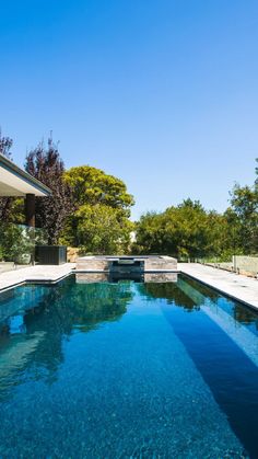 an empty swimming pool in front of a house