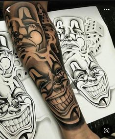 a man's arm with tattoos on it and two clown masks in the background