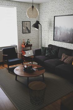 a living room filled with furniture and a laptop computer on top of a wooden table