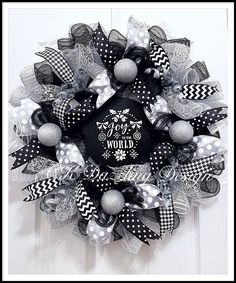 a black and white christmas wreath with polka dots, snowflakes and words on it