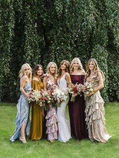 a group of women standing next to each other in dresses