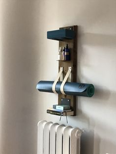 a wall mounted shelf with two yoga mats on it, and a towel rack attached to the wall