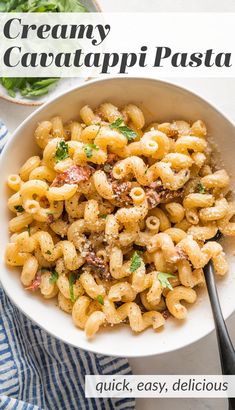 a white bowl filled with creamy cavatpi pasta and topped with parmesan cheese