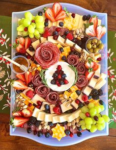 a platter filled with assorted fruits and cheeses