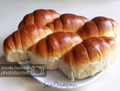 a white plate topped with rolls on top of a table