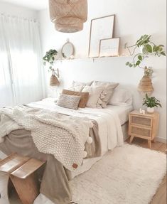 a bedroom with white walls and wooden flooring is decorated in neutral tones, including wicker accents