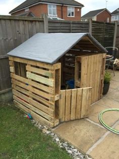 a wooden shed with a roof made out of pallets