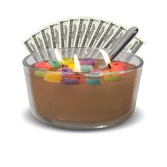 a small glass bowl filled with lots of candy and lit candles on top of it