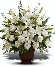 white flowers and greenery in a brown vase