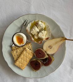 a white plate topped with fruit and crackers