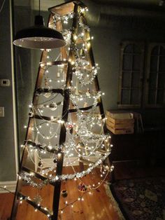 a christmas tree made from an old ladder is lit up with lights and garlands