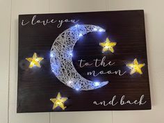 a wooden sign with string lights on it that says i love you to the moon and back