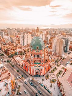 an aerial view of a large building with a green dome in the middle of a city