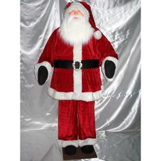 a large stuffed santa clause standing on top of a white sheet