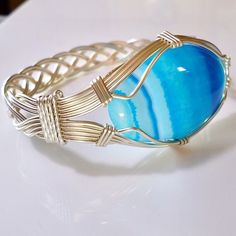 a close up of a bracelet with a blue stone on it's center piece