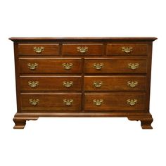 an old wooden dresser with many drawers and gold hardware on the top, against a white background