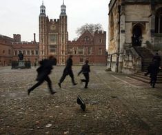 some people are running around in front of an old building and one person is on the ground