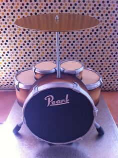 a set of drums sitting on top of a wooden table in front of a polka dot wall