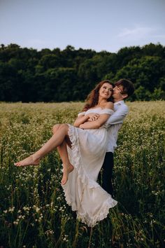 a man and woman are hugging in a field