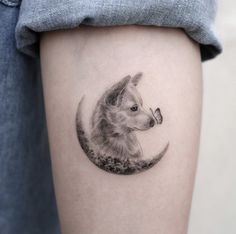 a dog is sitting on the moon with its nose in it's mouth tattoo