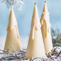 three small christmas trees sitting on top of snow covered ground