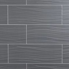 a gray tile wall with wavy lines on it