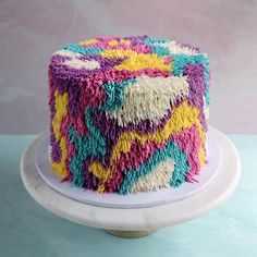 a multicolored cake sitting on top of a white plate