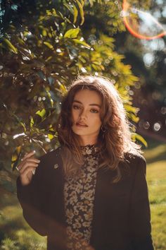 a woman standing in front of a tree