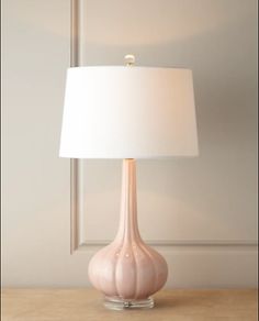 a white lamp sitting on top of a wooden table