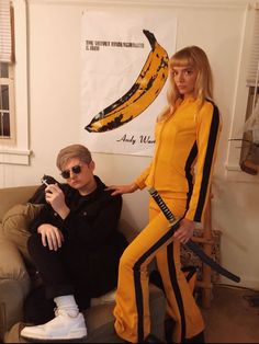 a man and woman in costumes sitting on a couch next to a banana peel costume