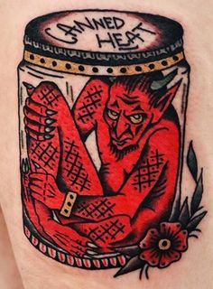 a man with a red tattoo on his arm has a jar full of stuff in it