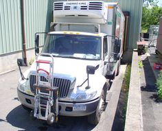 a white truck parked next to a green building