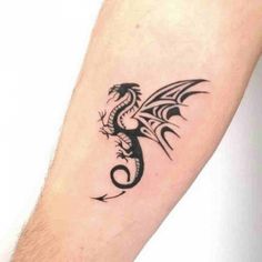 a black dragon tattoo on the left forearm and arm, with an arrow in the middle