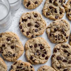 chocolate chip cookies on a baking sheet with glass of milk