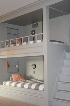 the bunk bed is built into the side of the wall and has stairs leading up to it