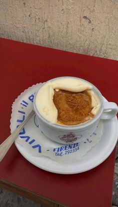 a bowl of food sitting on top of a red table next to a white plate