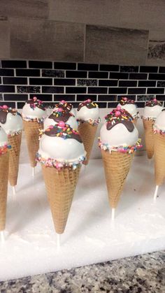 ice cream cones with sprinkles and chocolate on them are lined up in a row