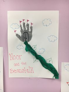 handprints and paper on a pink wall with green ribbon hanging from the middle