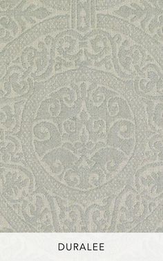 a white wallpaper with an ornate design in the middle and bottom corner, on top of