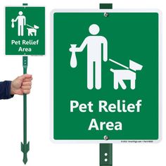 a person holding up a sign that says pet relief area