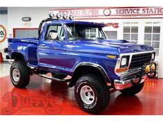 a large blue truck parked inside of a garage