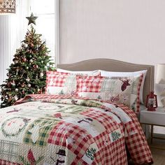 a christmas themed bed with a tree in the corner and plaid bedspread on it